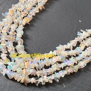 May include: A strand of iridescent white opal chip beads. The beads are irregular in shape and have a natural, raw look. The beads are strung on a clear thread and are ready to be used in jewellery making.