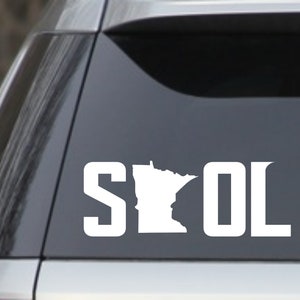 May include: White vinyl decal of the state of Minnesota with the letters "SOL" on either side. The decal is on a gray car window.