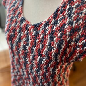 May include: A red, white and blue crocheted top with a loose, open weave.