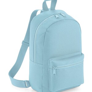 K&ouml;nnte beinhalten: Ein hellblauer Rucksack mit einem Hauptfach mit Rei&szlig;verschluss und einer kleineren Vordertasche mit Rei&szlig;verschluss. Der Rucksack verf&uuml;gt &uuml;ber verstellbare Schultergurte und einen Tragegriff an der Oberseite, alles aus passendem hellblauem Stoff mit farblich abgestimmten Rei&szlig;verschl&uuml;ssen.