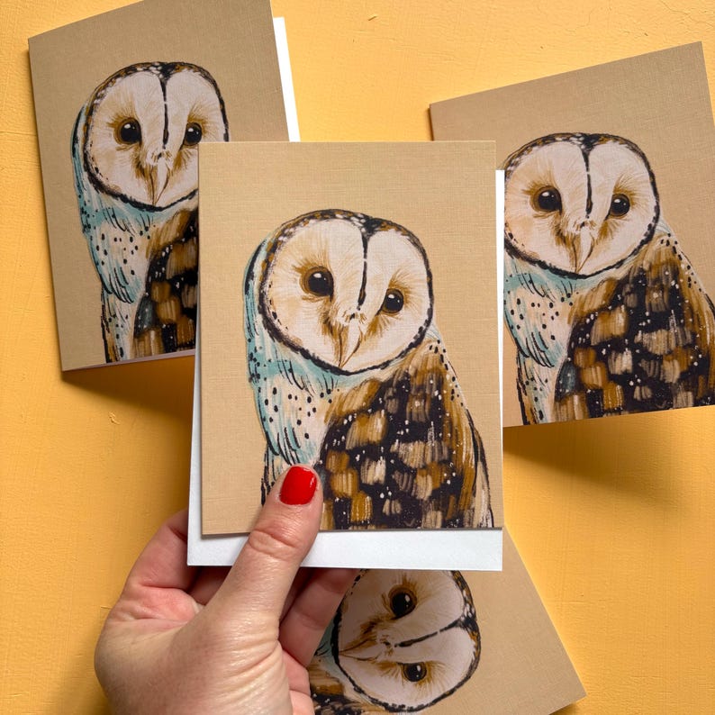 May include: A set of greeting cards featuring a hand-drawn illustration of a barn owl with a heart-shaped face, large dark eyes, and brown, white, and black plumage. The owl is depicted against a plain tan background on each card.