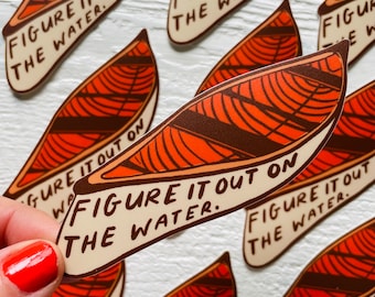 May include: A sticker featuring a canoe illustration and the text "Figure it out on the water." The canoe is orange and brown with a white background.