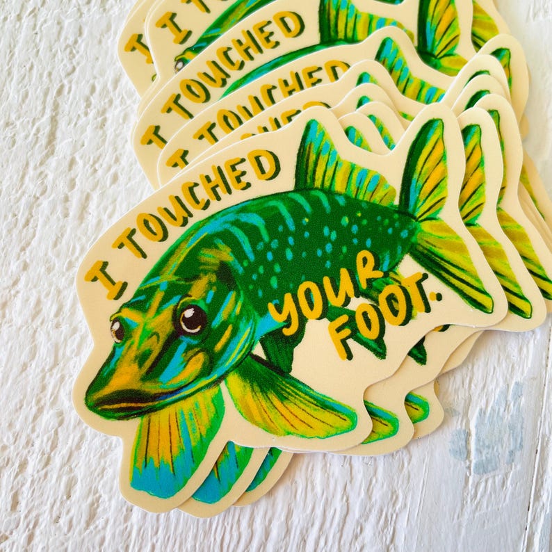 May include: A sticker featuring a cartoon illustration of a green and yellow fish with the text "I touched your foot."