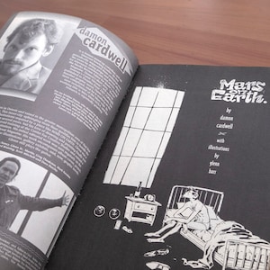 May include: A black and white comic book titled "Mars on Earth" by Damon Cardwell with illustrations by Glenn Barr. The cover features a black and white illustration of a person lying in bed reading a book.