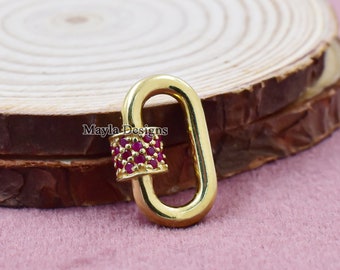 May include: Gold-toned oval-shaped lobster clasp with a red crystal-encrusted band. Mayla Designs is printed on the band.