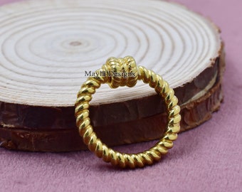 May include: A gold-colored ring with a twisted rope design and a knot at the top.