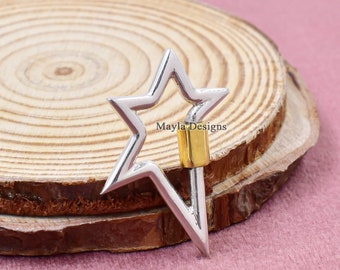 May include: A silver star-shaped carabiner with a gold accent. The carabiner is on a wooden surface.