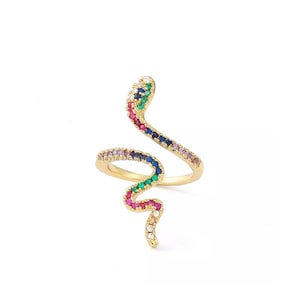Peut inclure: Une bague en or avec un motif de serpent coloré. Le serpent est orné de petites pierres précieuses multicolores, dont du rouge, du bleu, du vert et du rose.
