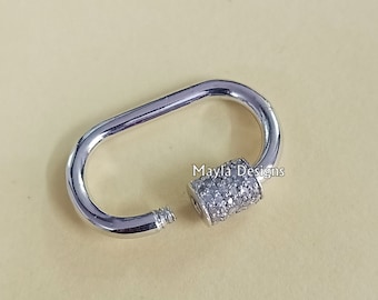 May include: Silver oval-shaped clasp with a small, round, silver bead encrusted with clear rhinestones. The clasp is open and the bead is visible. "Mayla Designs" is written in white text on the background.