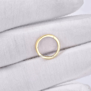 Può includere: Un anello a cerchio senza cuciture dorato per piercing del corpo. L'anello è in metallo e ha una finitura liscia e lucida.