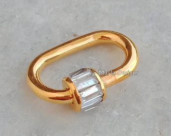 Könnte beinhalten: Ovaler Verschluss in Goldton mit einem klaren Kristall-Akzent. Mayla Designs ist auf dem Bild aufgedruckt.