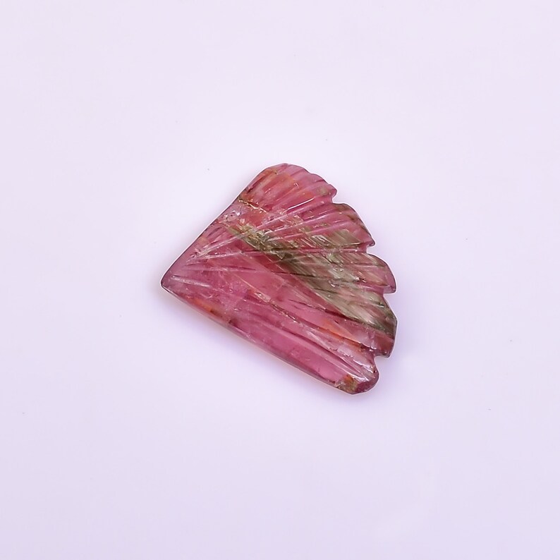 May include: A pink and green carved gemstone with a fan-like shape.