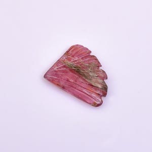 May include: A pink and green carved gemstone with a fan-like shape.