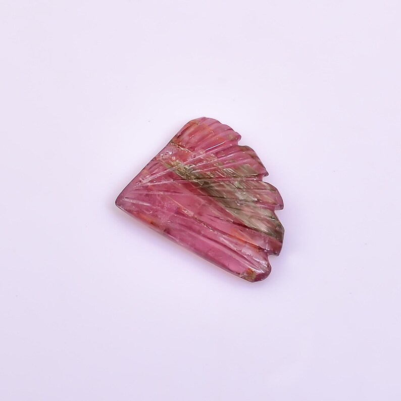 May include: A pink and green carved gemstone with a fan-like shape.