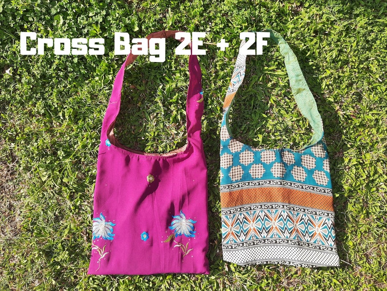 Pu&ograve; includere: Due borse a tracolla sono appoggiate sull'erba verde. Una &egrave; magenta con ricami floreali blu. L'altra &egrave; decorata con motivi geometrici turchese, arancione e bianchi. Il testo "Cross Bag 2E + 2F" &egrave; in alto.