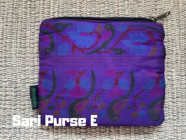 K&ouml;nnte beinhalten: Lila und schwarze gemusterte Stofftasche mit Rei&szlig;verschluss und dem Text "greenliving" an der Seite. Sari Purse E.