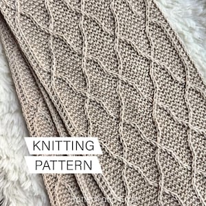 May include: A knitted scarf in a neutral beige color with a diamond pattern. The scarf is folded over, showing the texture of the knit. The words "KNITTING PATTERN" are displayed in a white rectangle.