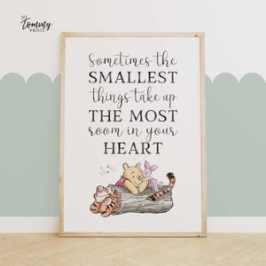 Nursery wall art with Winnie the Pooh, Piglet, and Tigger lying on a log under a sweet quote: “Sometimes the smallest things take up the most room in your heart.”