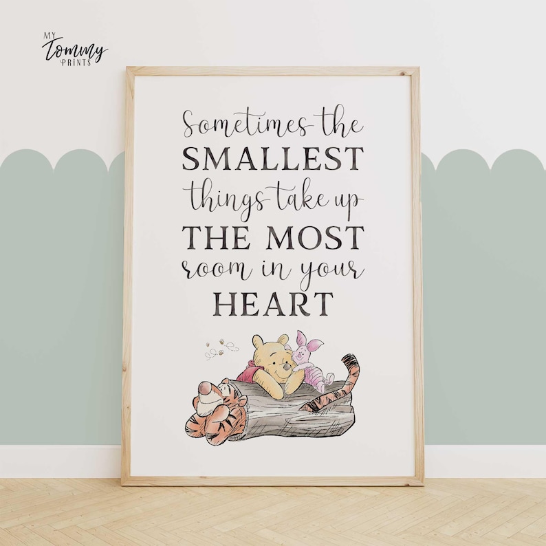 Nursery wall art with Winnie the Pooh, Piglet, and Tigger lying on a log under a sweet quote: “Sometimes the smallest things take up the most room in your heart.”
