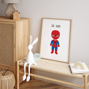 Op de afbeelding: Een printable poster met een cartoonillustratie van Spiderman in een rood en blauw pak. De poster heeft de tekst "Be Kind" bovenaan.