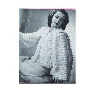 Peut inclure: Une photo vintage en noir et blanc d'une femme portant une veste en crochet blanc avec un design à volants. La veste a des manches longues et une longueur courte.