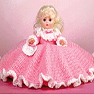 May include: A pink crocheted doll dress with white lace trim. The doll has blonde hair and blue eyes.