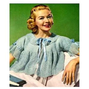 May include: A light blue crocheted top with a ruffled collar and a bow tie. The top has short sleeves and a loose fit.