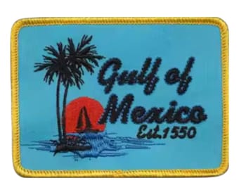 Pode incluir: Um remendo bordado azul e amarelo com um pôr do sol, palmeiras e o texto "Gulf of Mexico Est. 1550".