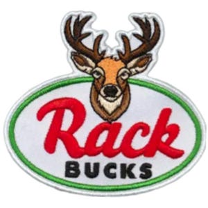 Könnte beinhalten: Ein weißer ovaler Patch mit grünem Rand. Der Patch zeigt das Wort "Rack" in roter Kursivschrift und die Wörter "Bucks" in Schwarz darunter. Oberhalb des Textes befindet sich ein Cartoon-Bild eines braunen und weißen Hirschkopfes mit Geweih.