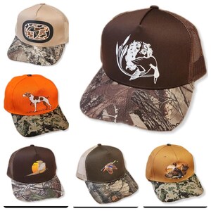 以下が含まれることがあります： 刺繍されたデザインが施された、6種類の迷彩柄のベースボールキャップ。キャップは、茶色、タン、オレンジのクラウンに、迷彩柄のメッシュバックが付いています。デザインには、アヒル、犬、鳥が含まれています。