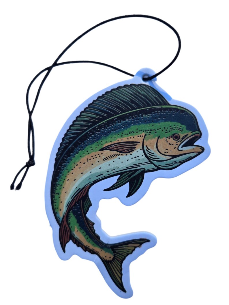 May include: A blue air freshener shaped like a fish, featuring a detailed illustration in shades of green, yellow, and brown. The fish is outlined in black and has a black string for hanging. The air freshener has a light blue border.