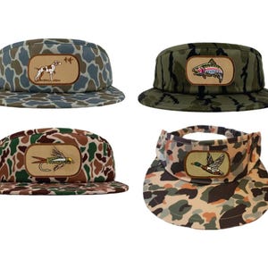 Puede incluir: Cuatro gorras de béisbol de camuflaje diferentes con parches bordados. Los parches representan un perro, un pez, una mosca y un pato.