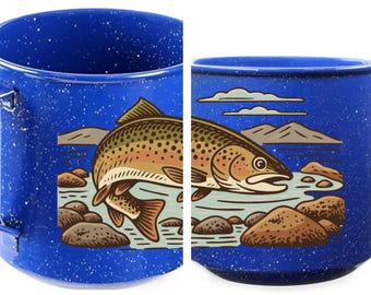 Puede incluir: Taza de camping de esmalte azul con un acabado moteado y un asa grande. La taza presenta una ilustración detallada de una trucha en una escena de río con rocas y montañas. El pez es marrón, naranja y amarillo.