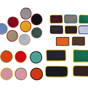 May include: Assortment of round and rectangular fabric patches in various colours, including red, blue, green, yellow, orange, brown, black, and white. The patches have a yellow or blue border.