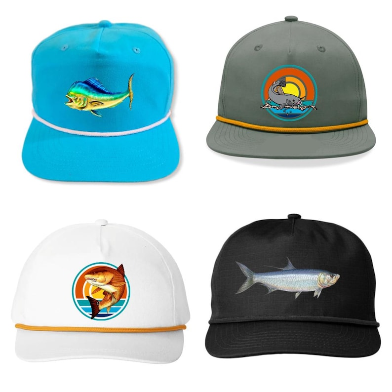 Pu&ograve; includere: Quattro cappellini da baseball con disegni di pesci. Un cappellino turchese presenta un pesce colorato. Un cappellino grigio ha una grafica di squalo. Un cappellino bianco mostra un pesce in un design al tramonto. Un cappellino nero mostra un pesce argentato.