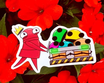 Könnte beinhalten: Ein Aufkleber mit einer roten Cartoonfigur mit Krone, die eine Kiste voller bunter, gepunkteter Helme trägt. Der Aufkleber befindet sich vor einem Hintergrund aus leuchtend roten Blumen und grünen Blättern.
