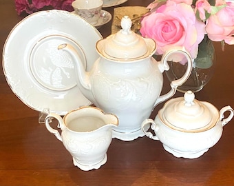 Royal Kent Poland Solid White: Raised relief baroque scrollwork 22kt gold rim; porcelain teapot, creamer, sugar, plate; 5 cup coffeepot new
