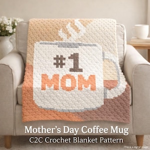 May include: A crocheted blanket featuring a coffee mug design with the text "#1 MOM" in brown and orange. The blanket is draped over a beige armchair. The text "Mother's Day Coffee Mug C2C Crochet Blanket Pattern" is at the bottom.