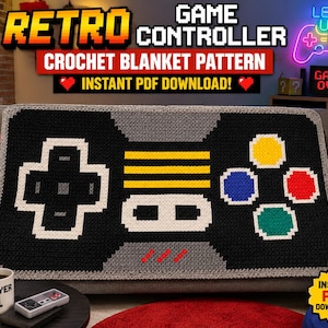May include: A rectangular crochet blanket featuring a pixelated design of a retro game controller. The blanket is primarily black and gray with a white directional pad, three yellow horizontal stripes, and four colored buttons in yellow, blue, red, and green.