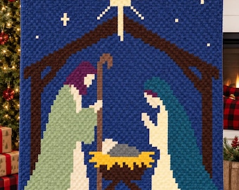 May include: A rectangular crochet blanket featuring a pixelated nativity scene. The design displays a dark blue background with a bright yellow star, a brown stable structure, and figures in light green, teal, and white, centered around a yellow manger.
