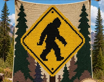 May include: A Bigfoot C2C crochet blanket pattern. The blanket features a yellow diamond sign with a black silhouette of Bigfoot. The design includes forest imagery and the text "80x100 Blocks" and "Instant PDF Download".