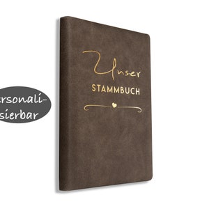 Könnte beinhalten: Ein braunes Kunstleder-Journal mit goldener Aufschrift "Unser Stammbuch".