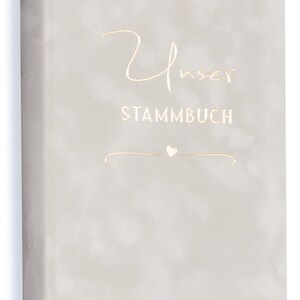 May include: A light gray book cover with the text "Unser Stammbuch" in gold lettering. A small heart symbol is below the text.