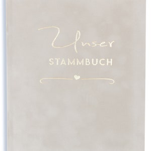 May include: A light gray book with the words "Unser Stammbuch" in gold lettering. A small heart symbol is above a decorative line.