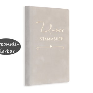 May include: A gray, textured book with the text "Unser Stammbuch" in gold lettering. The book is personalized with a small heart.
