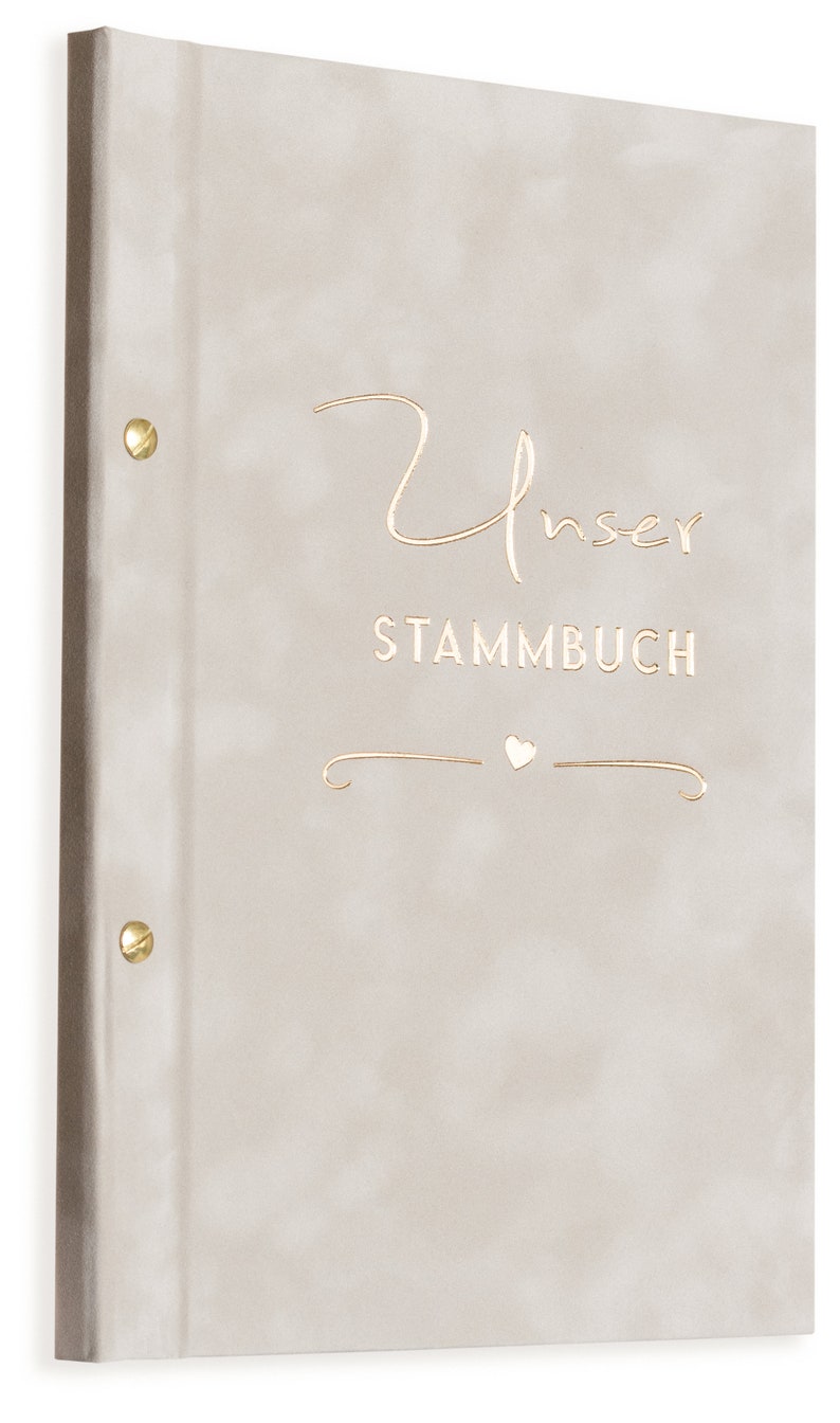 May include: A beige fabric-covered album with gold accents. The front cover features the text "Unser Stammbuch" with a small heart symbol.
