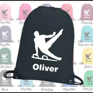 May include: A black drawstring bag with a white silhouette of a gymnast on a pommel horse. The bag has a white drawstring and the name "Oliver" is printed in white below the image.