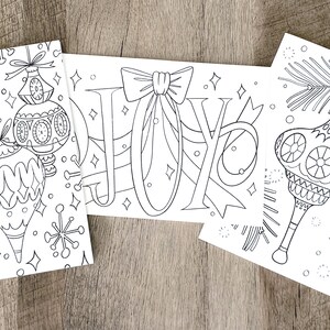May include: Three black and white coloring pages featuring Christmas ornaments and the word "JOY" with a bow.
