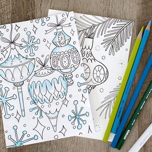 May include: A coloring page featuring three stylized Christmas ornaments with snowflake designs. The ornaments are outlined in black and ready to be colored in.