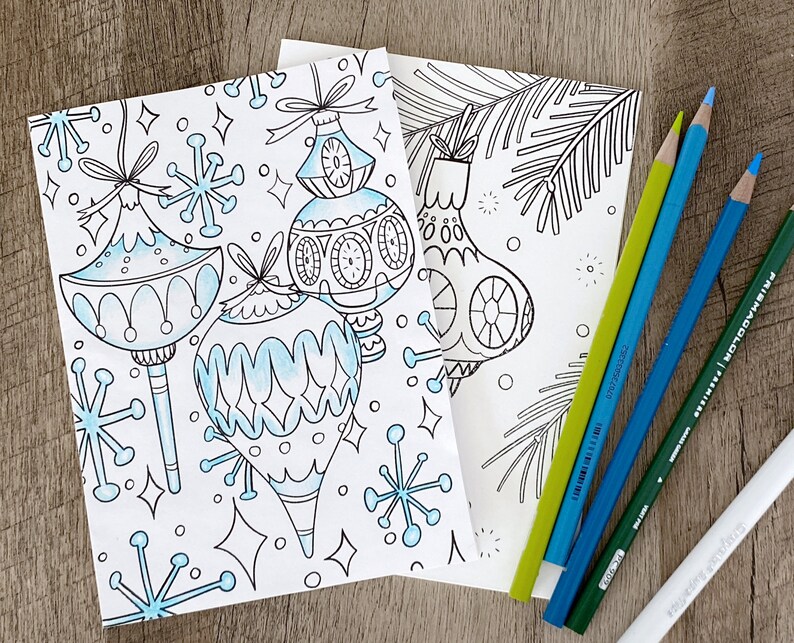 May include: A coloring page featuring three stylized Christmas ornaments with snowflake designs. The ornaments are outlined in black and ready to be colored in.